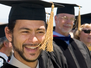 Smiling student in cap and gown at graduation ceremony